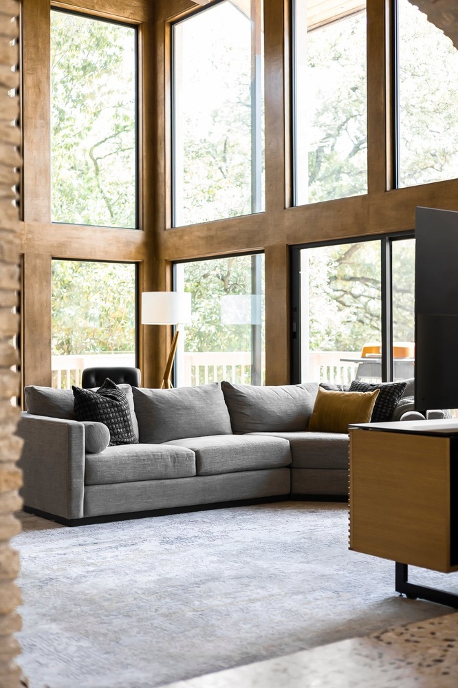 open concept living room with large windows and sectional sofa by RedOven Builds Austin TX remodel