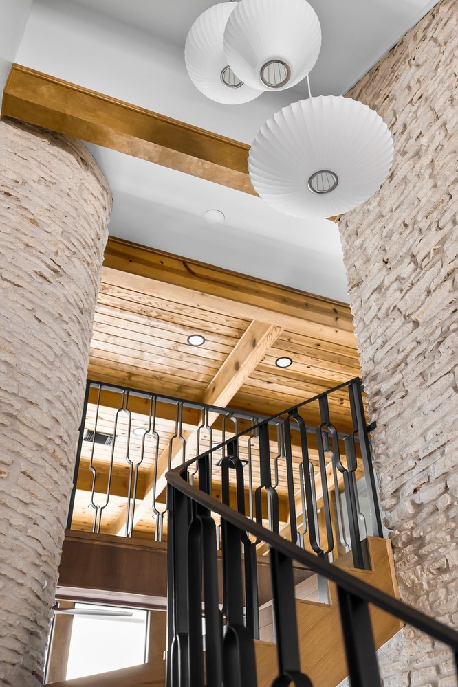 staircase view with pendant lighting and wood ceiling beams in Austin TX remodel by RedOven Builds