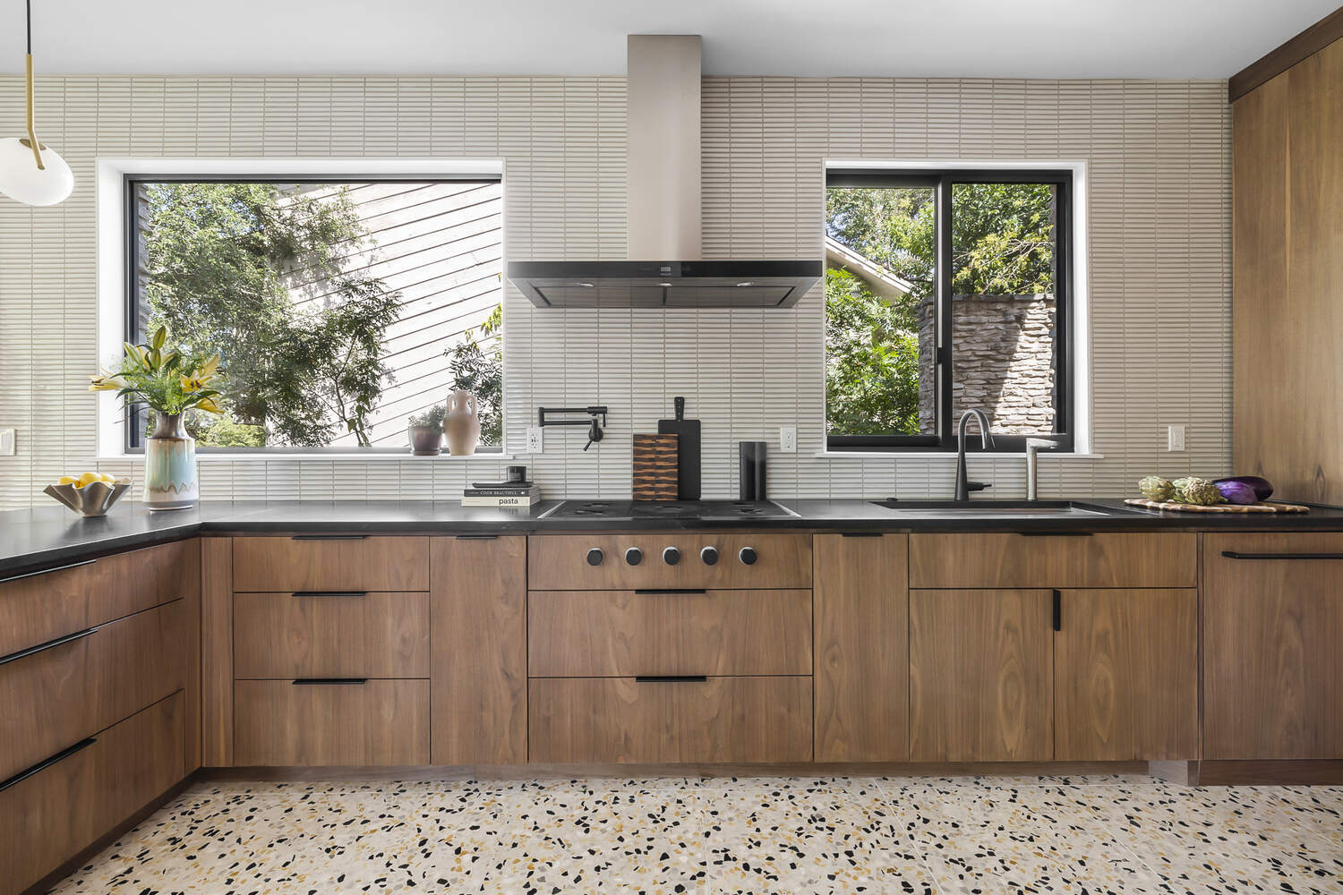 symmetrical kitchen design with range hood and walnut cabinetry by RedOven Builds Austin TX remodel