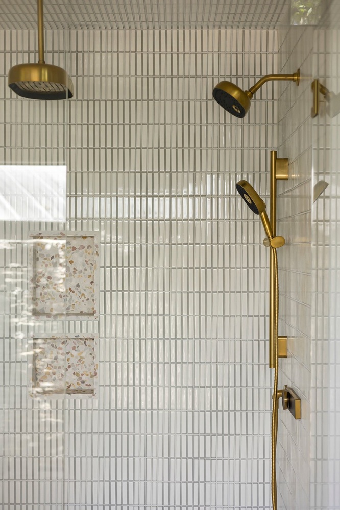 tiled shower with dual showerheads and brass fixtures in Austin TX remodel by RedOven Builds