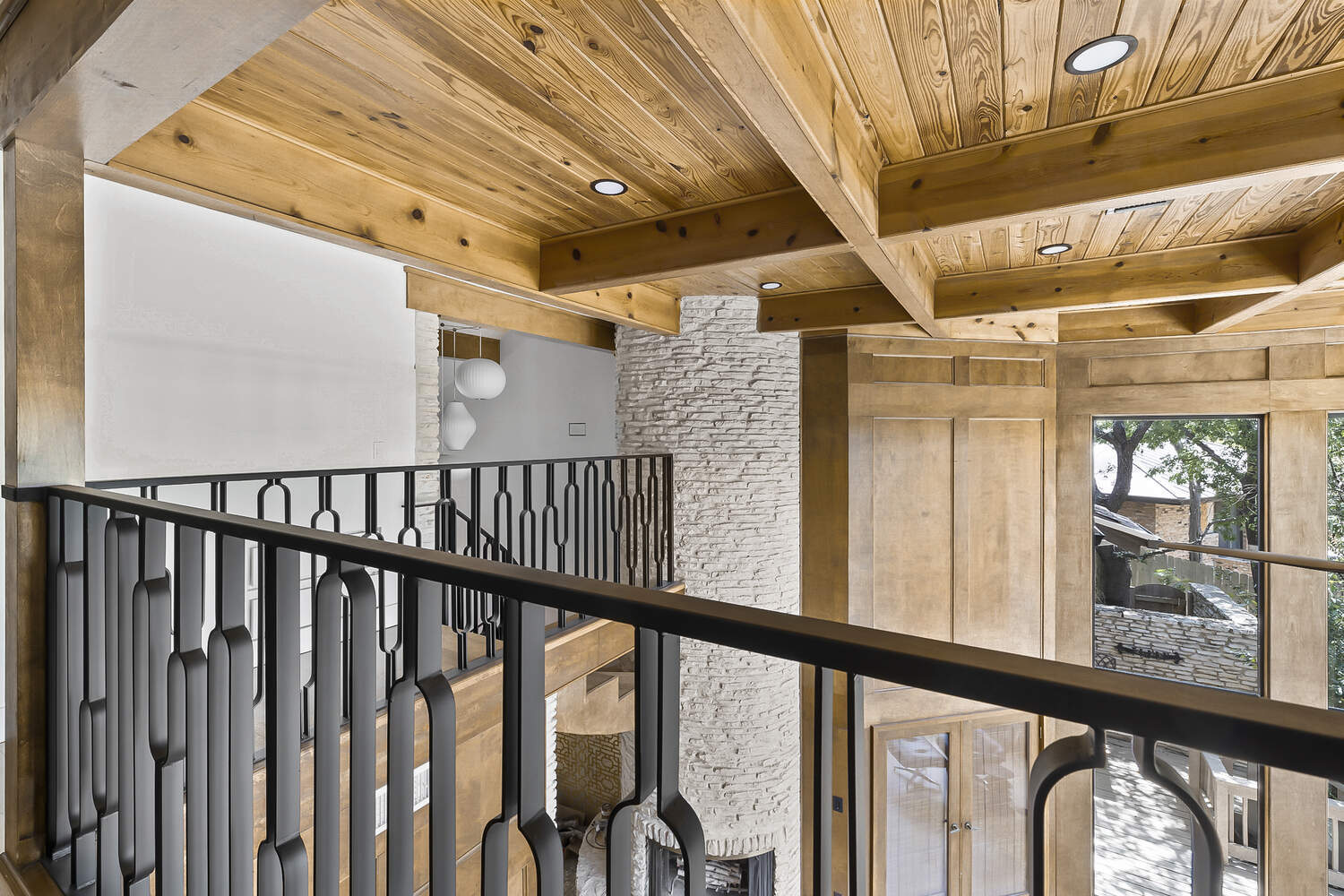 upstairs landing with wood beams and modern railing in Austin TX full remodel by RedOven Builds