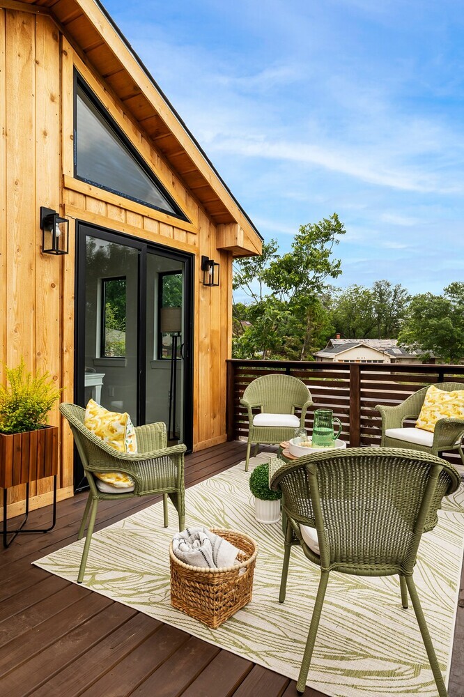 ADU exterior with wood siding and elevated deck seating area by RedOven Builds in Austin TX