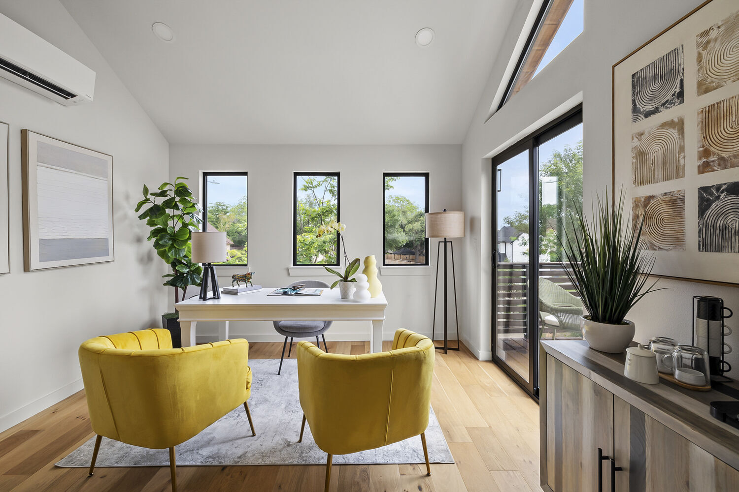 ADU interior office with desk, yellow chairs, and large windows by RedOven Builds in Austin, TX