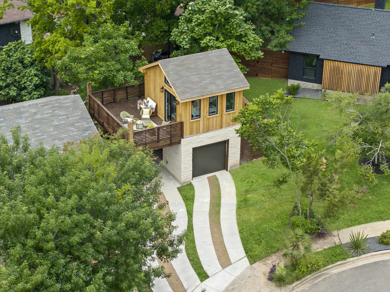 Aerial view of a custom ADU with rooftop deck by RedOven Builds in Austin, TX surrounded by greenery