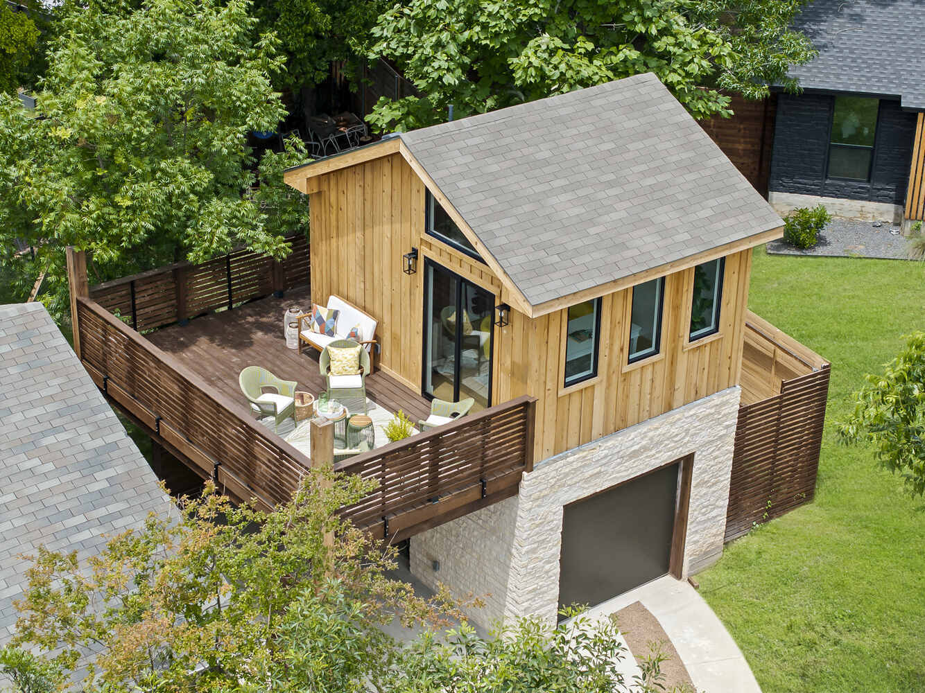 Angled aerial view of a custom ADU with deck and driveway by RedOven Builds in Austin, TX