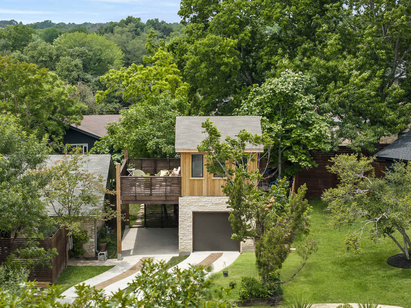 Backyard view of a custom ADU with elevated deck and garage by RedOven Builds in Austin, TX