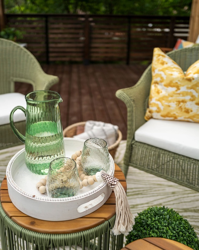 Cozy ADU balcony seating with decorative tray and patio furniture by RedOven Builds in Austin, TX