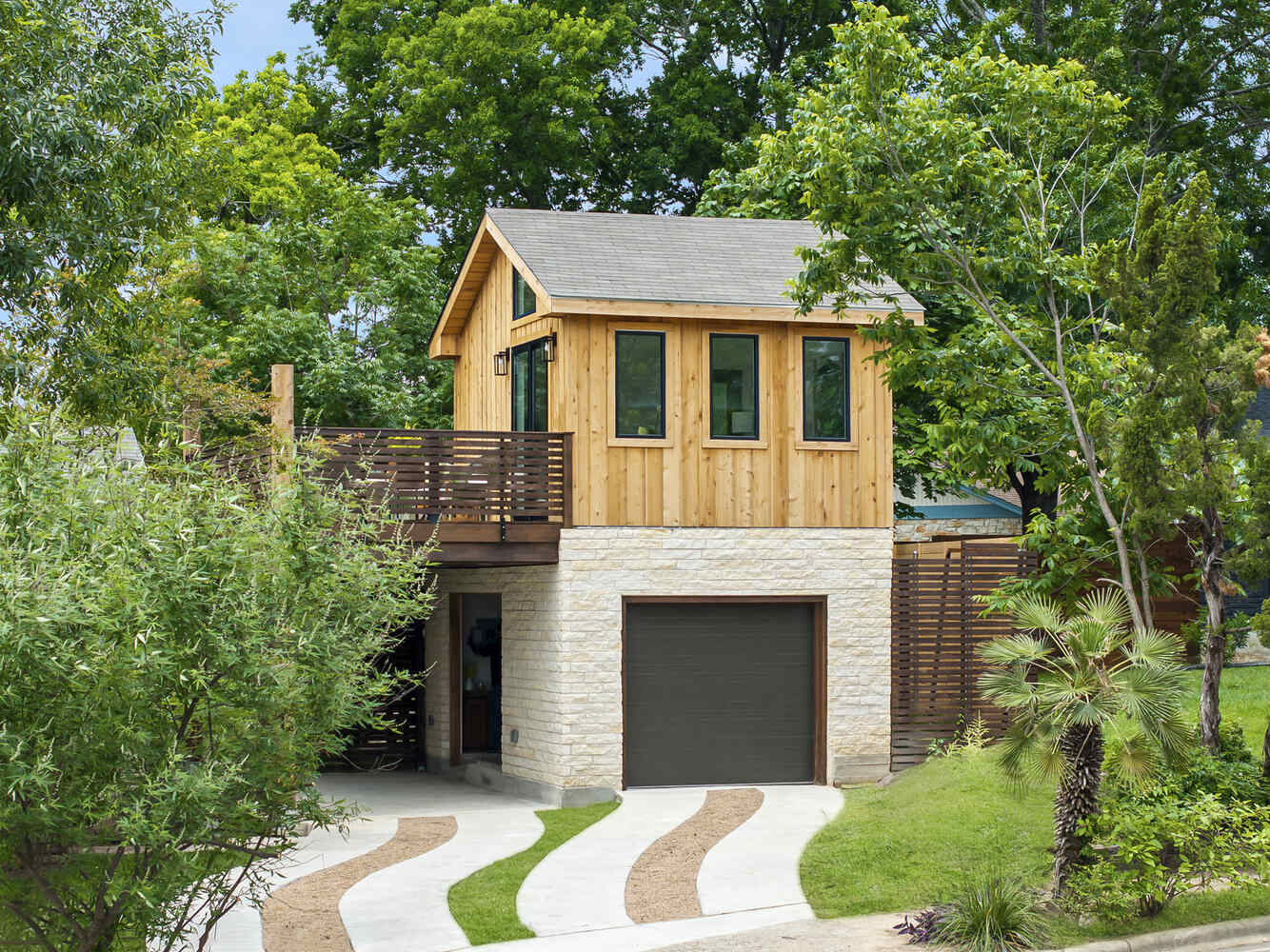 Front view of ADU with garage and wood siding by RedOven Builds in Austin, TX