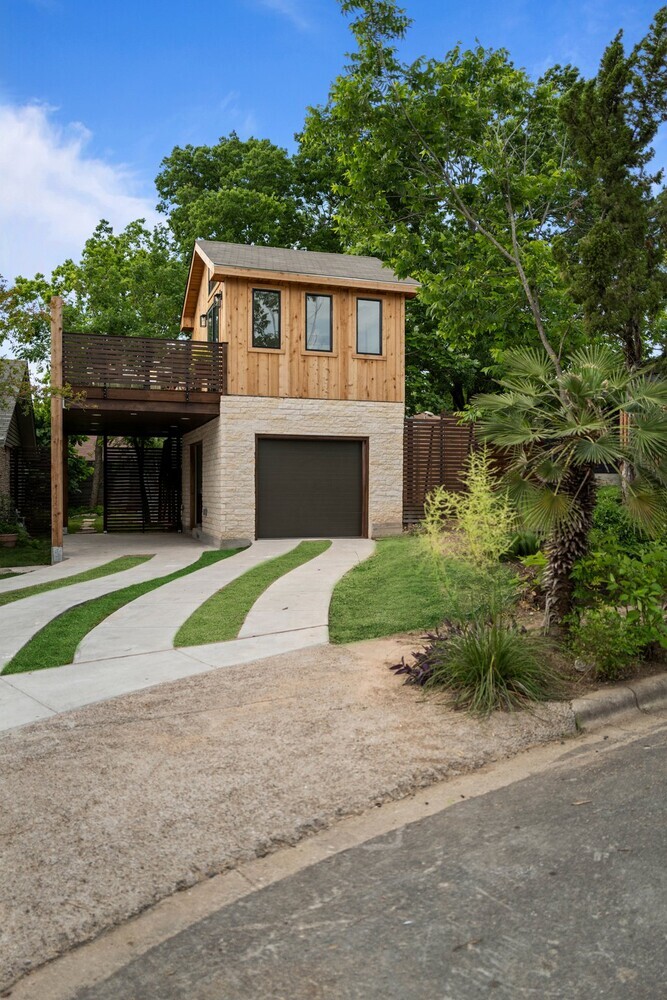 Modern ADU with garage, balcony, and curved driveway by RedOven Builds in Austin, TX