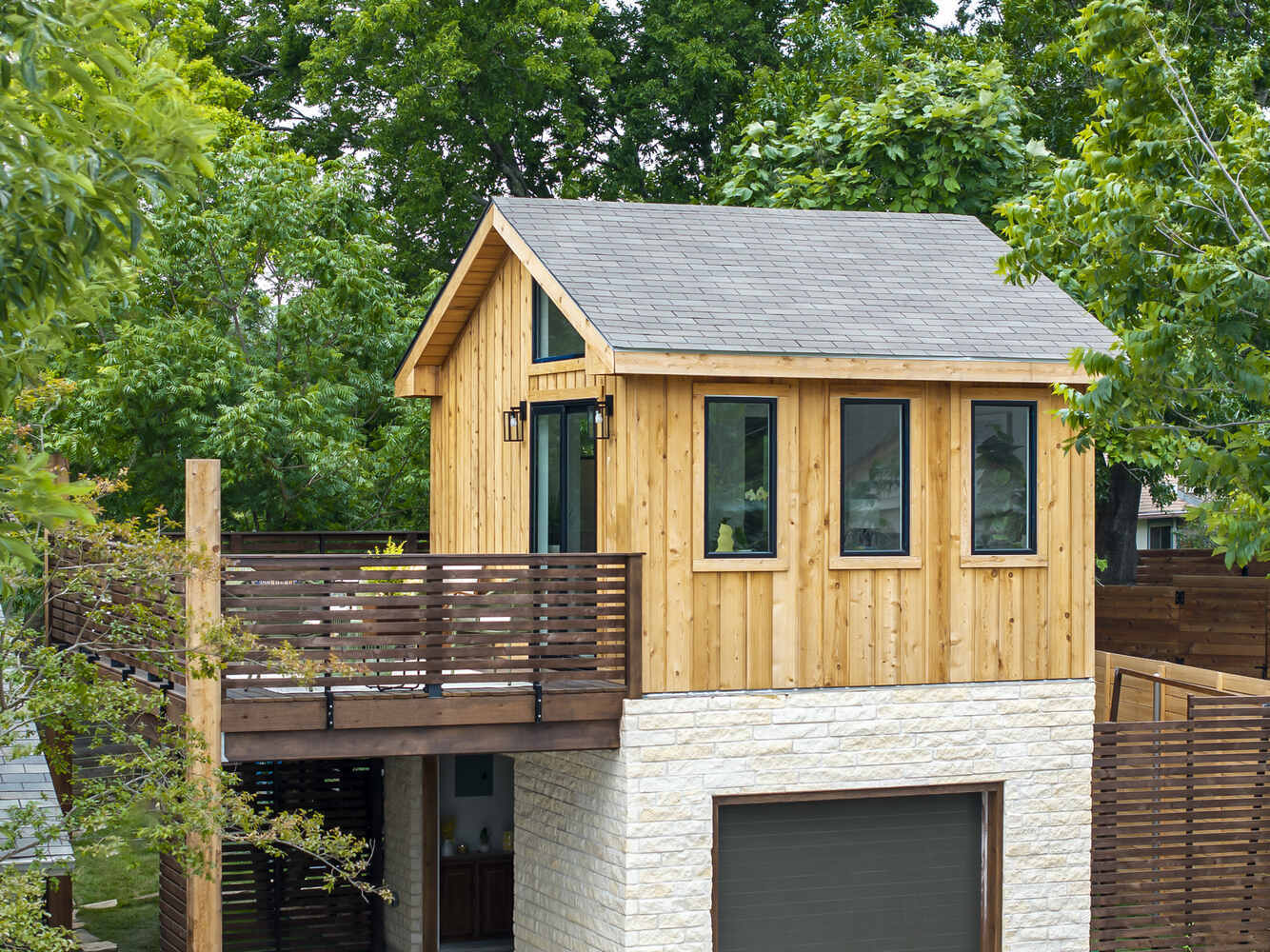 Modern ADU with wood siding and landscaped front yard by RedOven Builds in Austin, TX