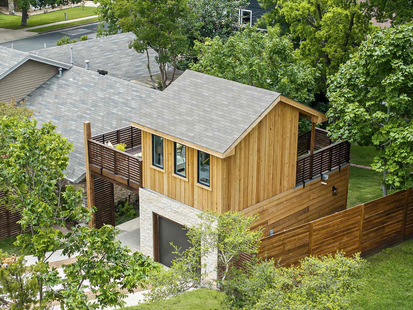 Rear aerial view of custom ADU with deck and privacy fencing by RedOven Builds in Austin, TX