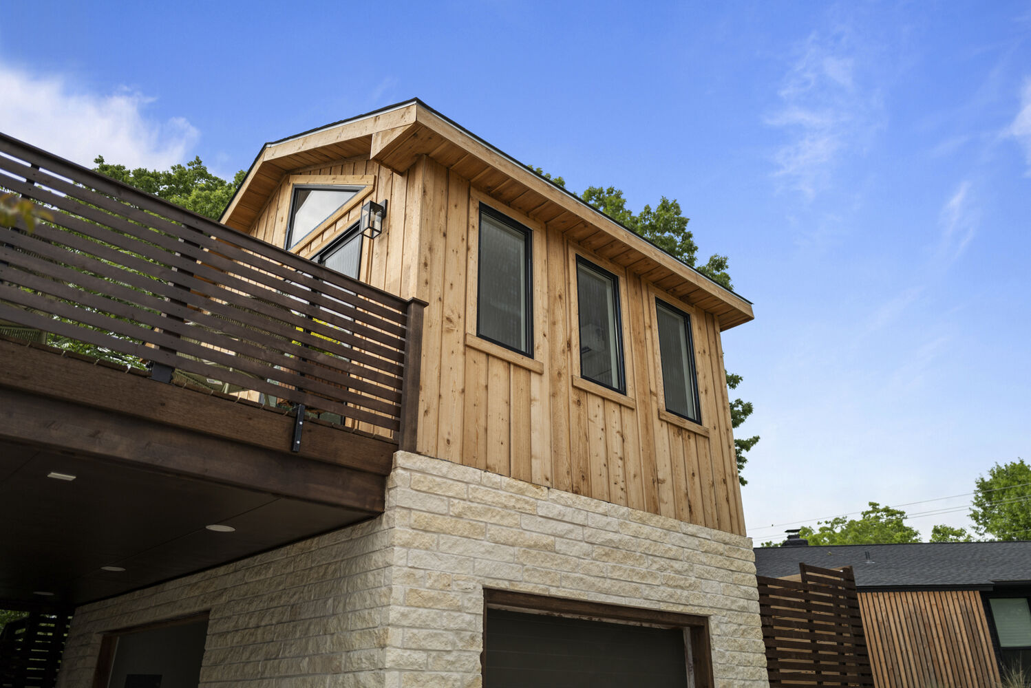 RedOven Builds ADU exterior showcasing wood siding and upper-level balcony in Austin, TX
