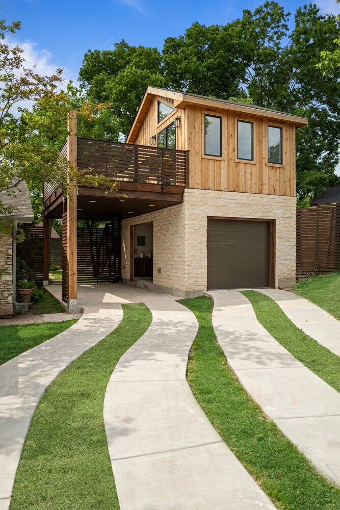 RedOven Builds ADU exterior with curved driveway, wood siding, and balcony in Austin, TX
