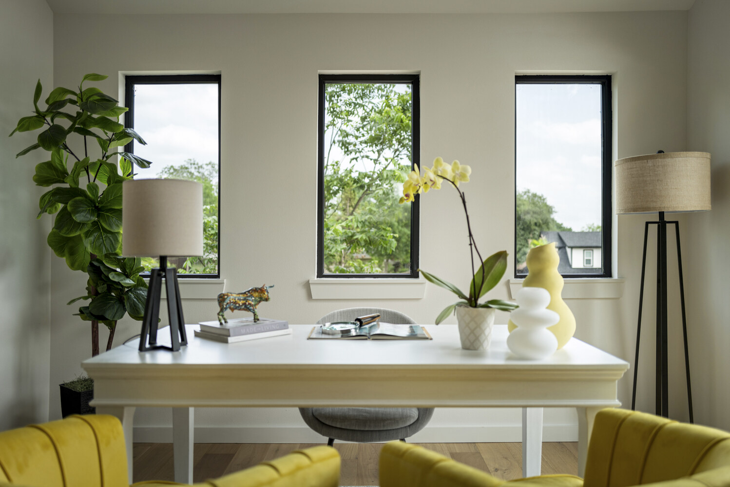 RedOven Builds ADU office with white desk, yellow chairs, and large windows in Austin, TX