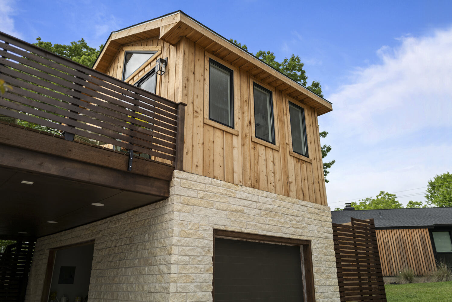 RedOven Builds modern ADU exterior with wood siding and balcony in Austin, TX