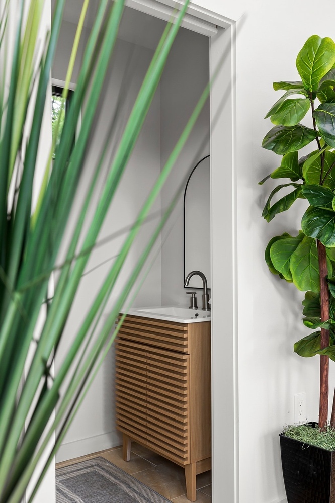 modern ADU bathroom vanity with wood slat cabinet and minimalist sink by RedOven Builds in Austin TX
