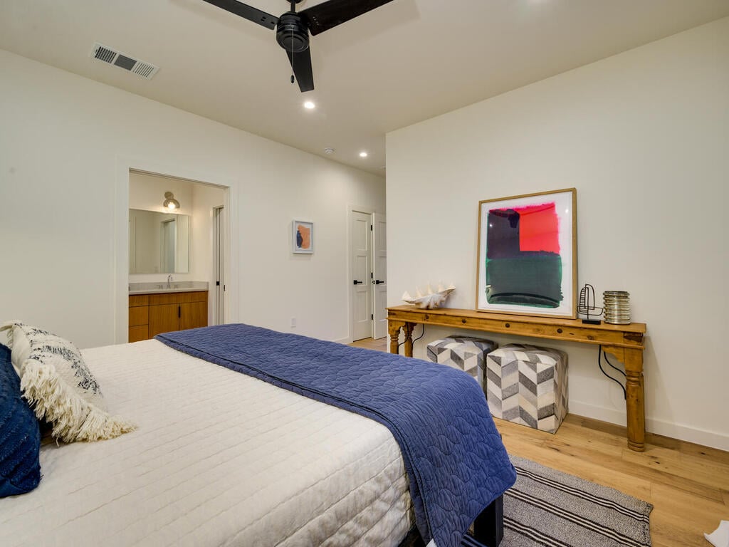 Custom new build bedroom with neutral tones and wood flooring by RedOven Builds in Austin, TX