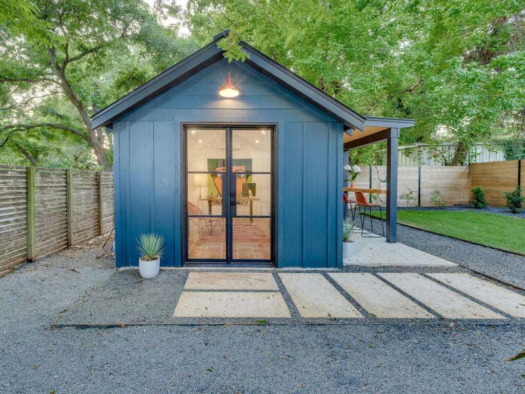Detached guest house with glass doors and outdoor seating by RedOven Builds in Austin, TX