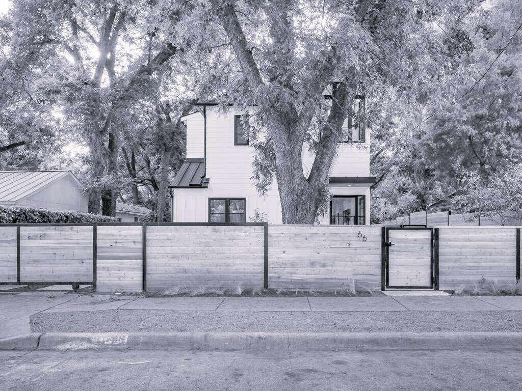 Modern home exterior behind privacy fence by RedOven Builds in Austin, TX monochrome