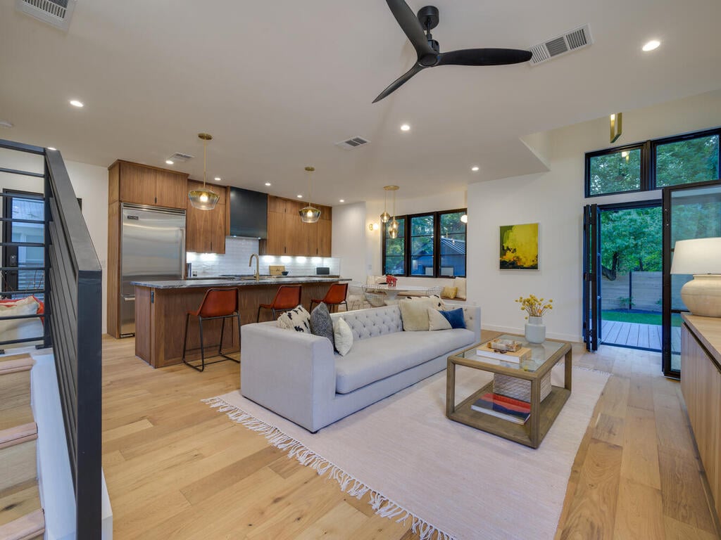 Modern living space with kitchen island and seating by RedOven Builds in Austin, TX