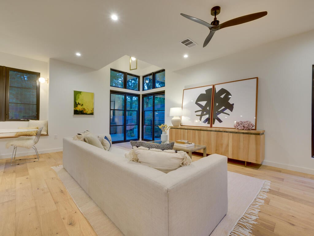 Open concept living room with natural light and modern decor by RedOven Builds in Austin, TX