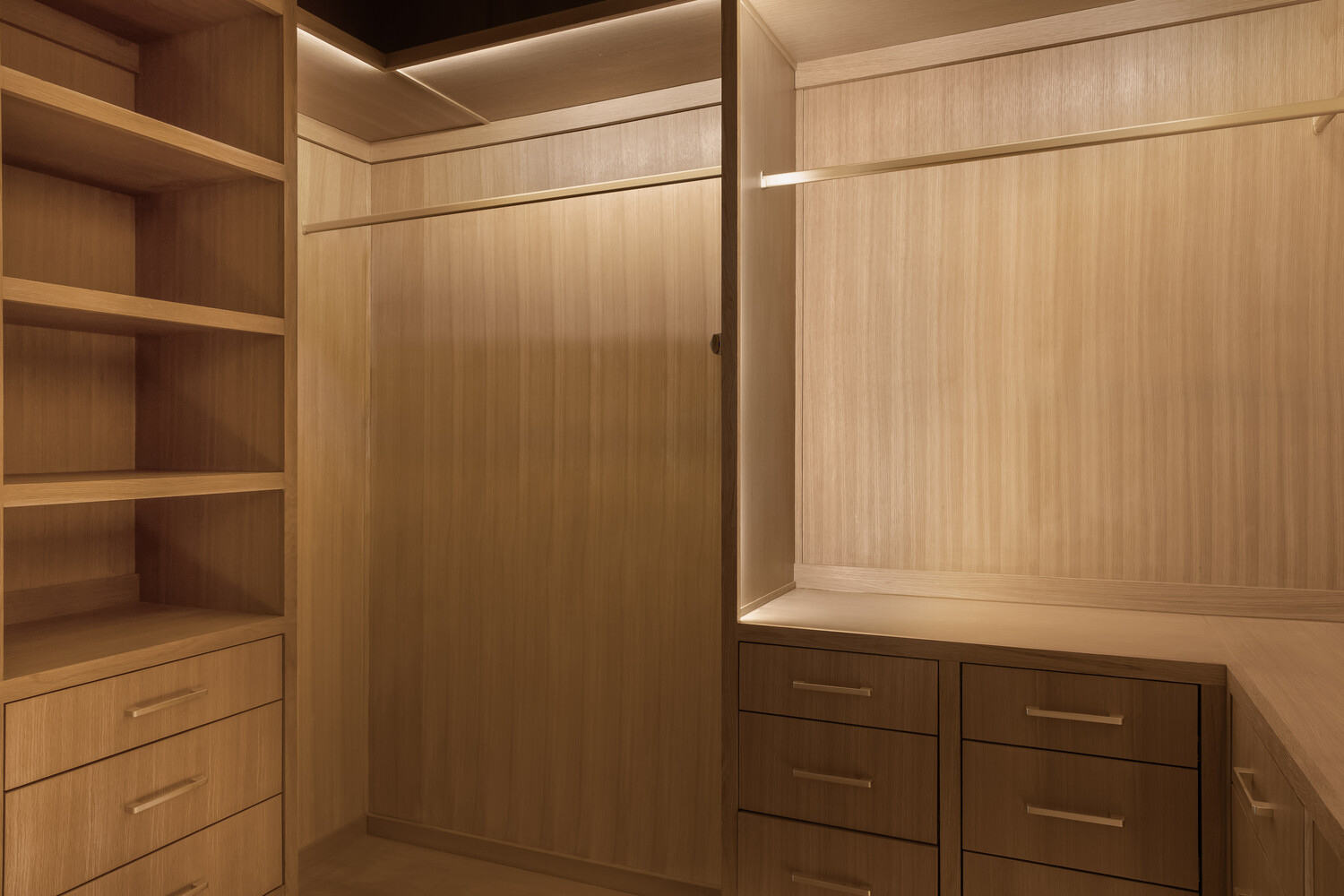 Modern closet design with integrated lighting and wood finishes by RedOven Builds in Austin, TX
