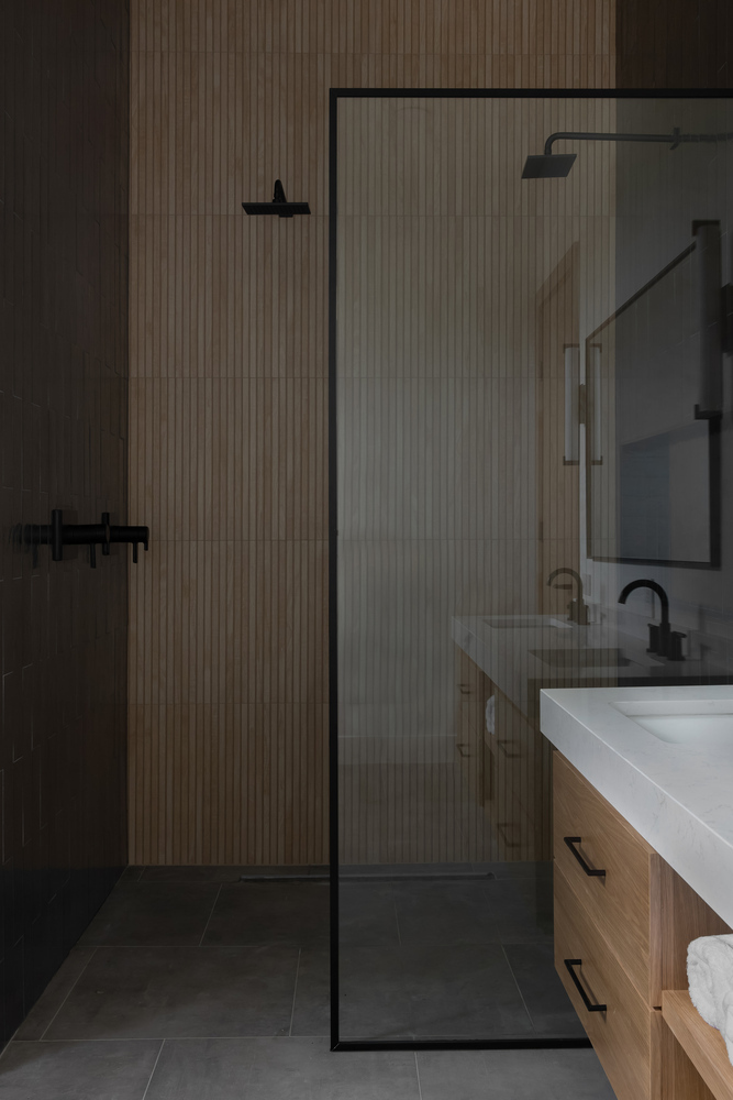 RedOven Builds modern bathroom with glass shower and wood vanity in Austin, TX