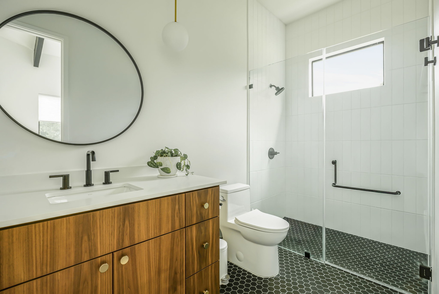 Bathroom with glass shower and wood vanity in RedOven Builds custom new build Rio Grande, TX