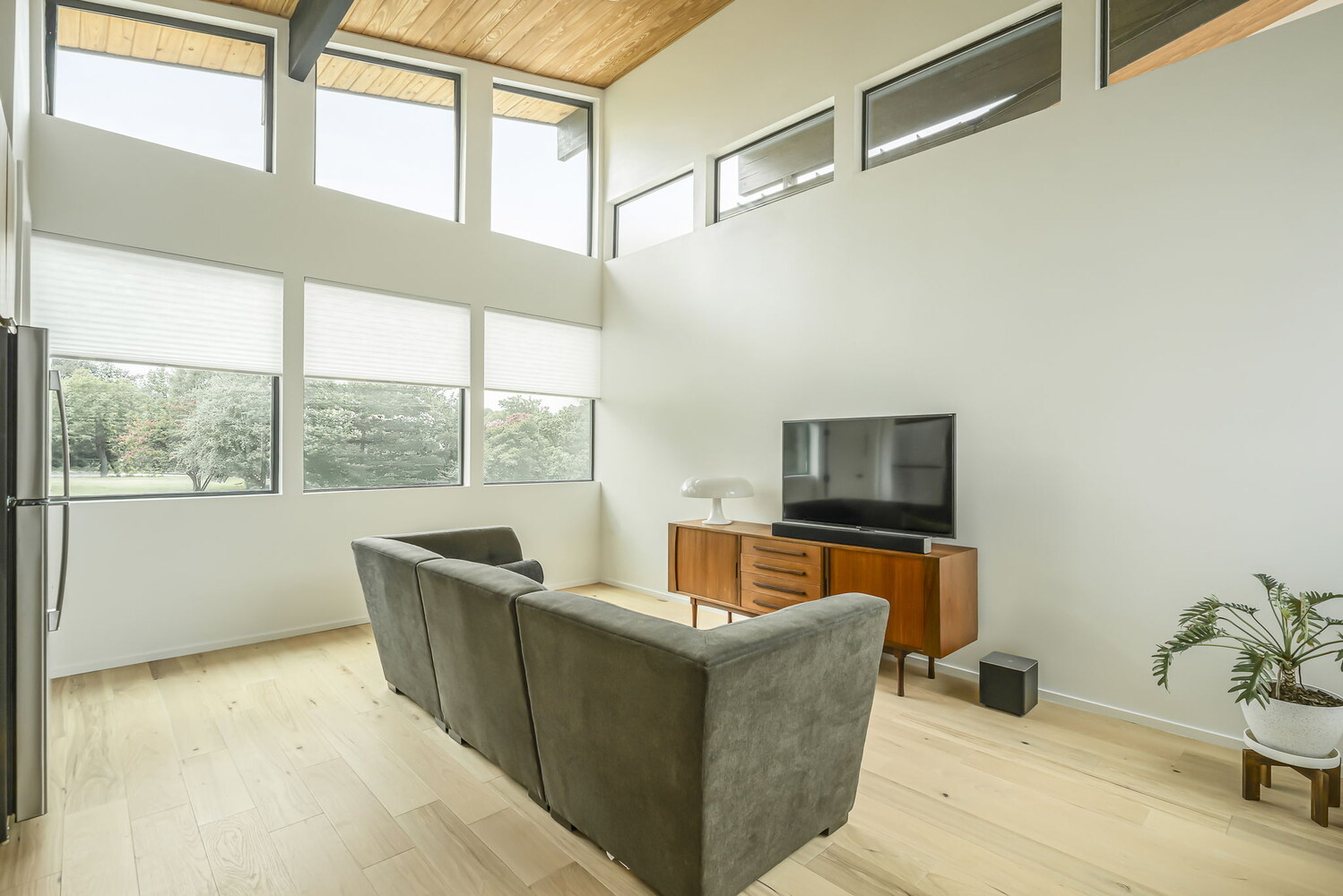 Minimalist living room with expansive windows and wood accents in a RedOven Builds custom new build Rio Grande, TX