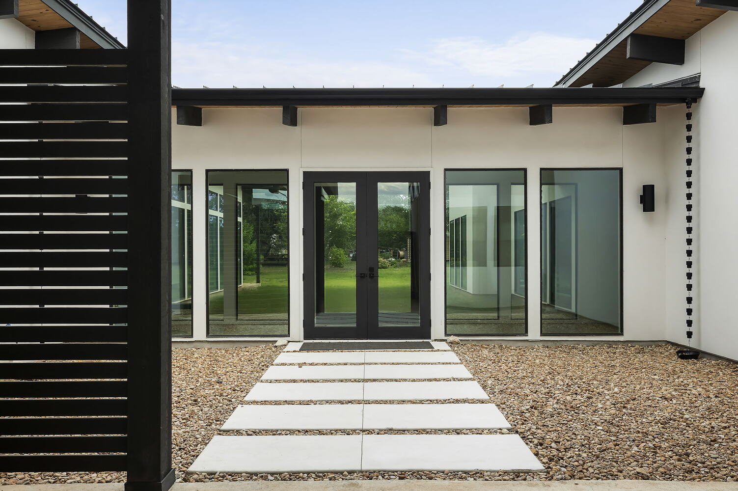 Modern exterior patio with glass doors and clean landscaping in RedOven Builds custom home Rio Grande, TX