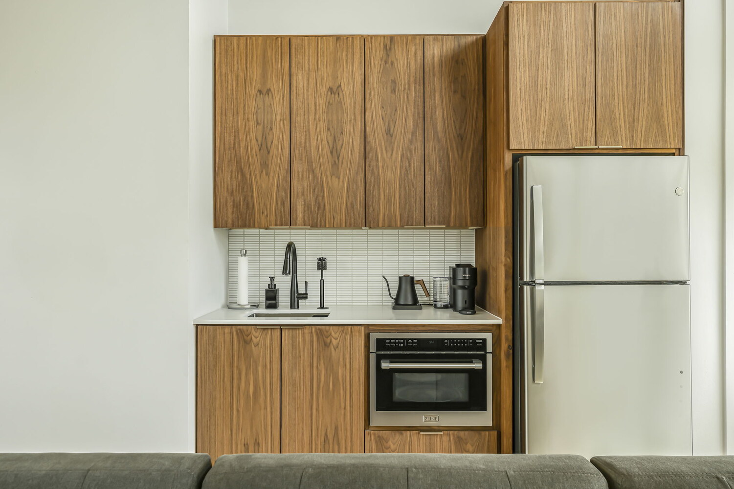 Modern kitchenette with sleek cabinetry and backsplash in RedOven Builds custom build Rio Grande, TX