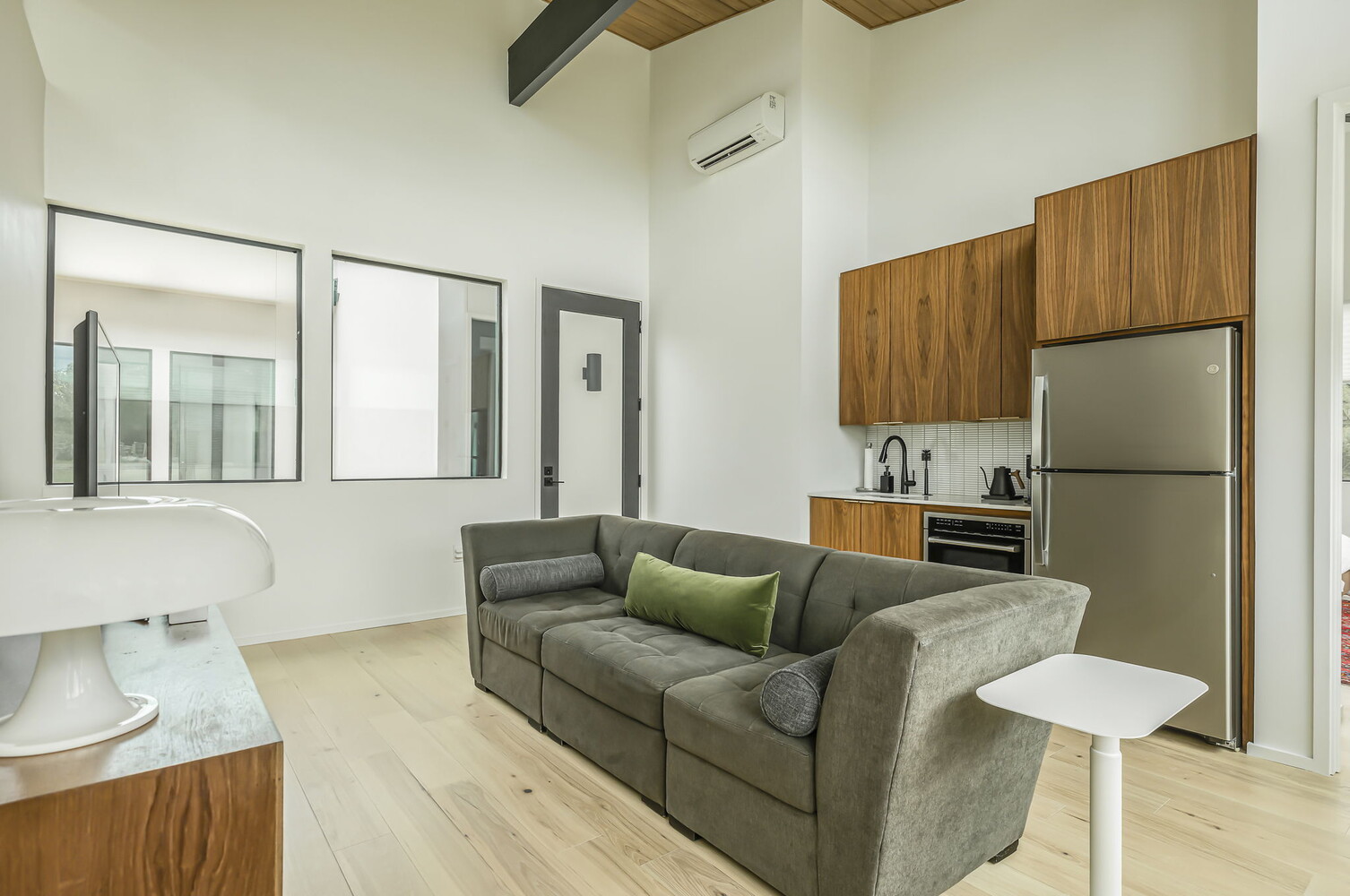 Modern living room with compact kitchen and high ceilings in RedOven Builds custom new build Rio Grande, TX