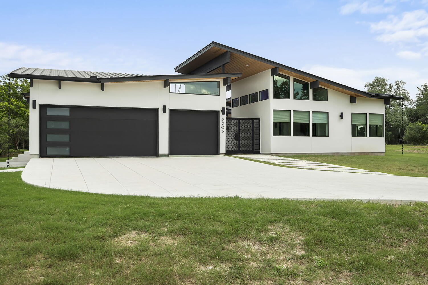 angled view of modern custom home with dual garages by RedOven Builds in San Juan Dr Rio Grande TX