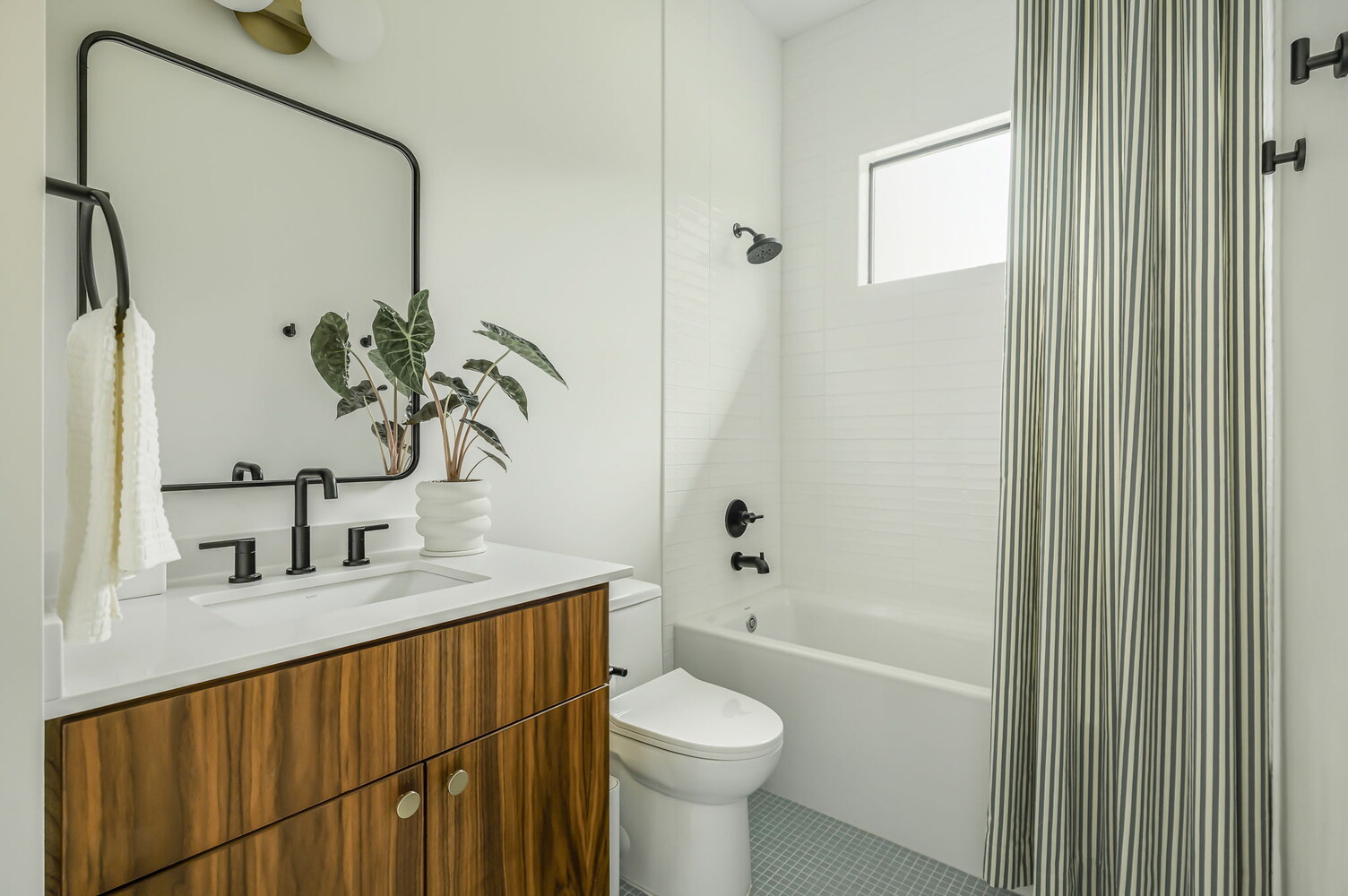 bright bathroom interior in RedOven Builds custom home with clean white finishes and wood cabinetry in Rio Grande TX