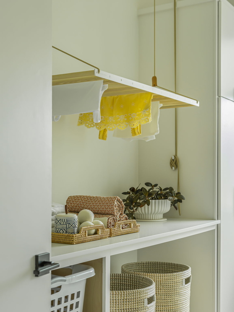 close-up of modern laundry room with suspended drying rack and storage decor by RedOven Builds in Rio Grande TX