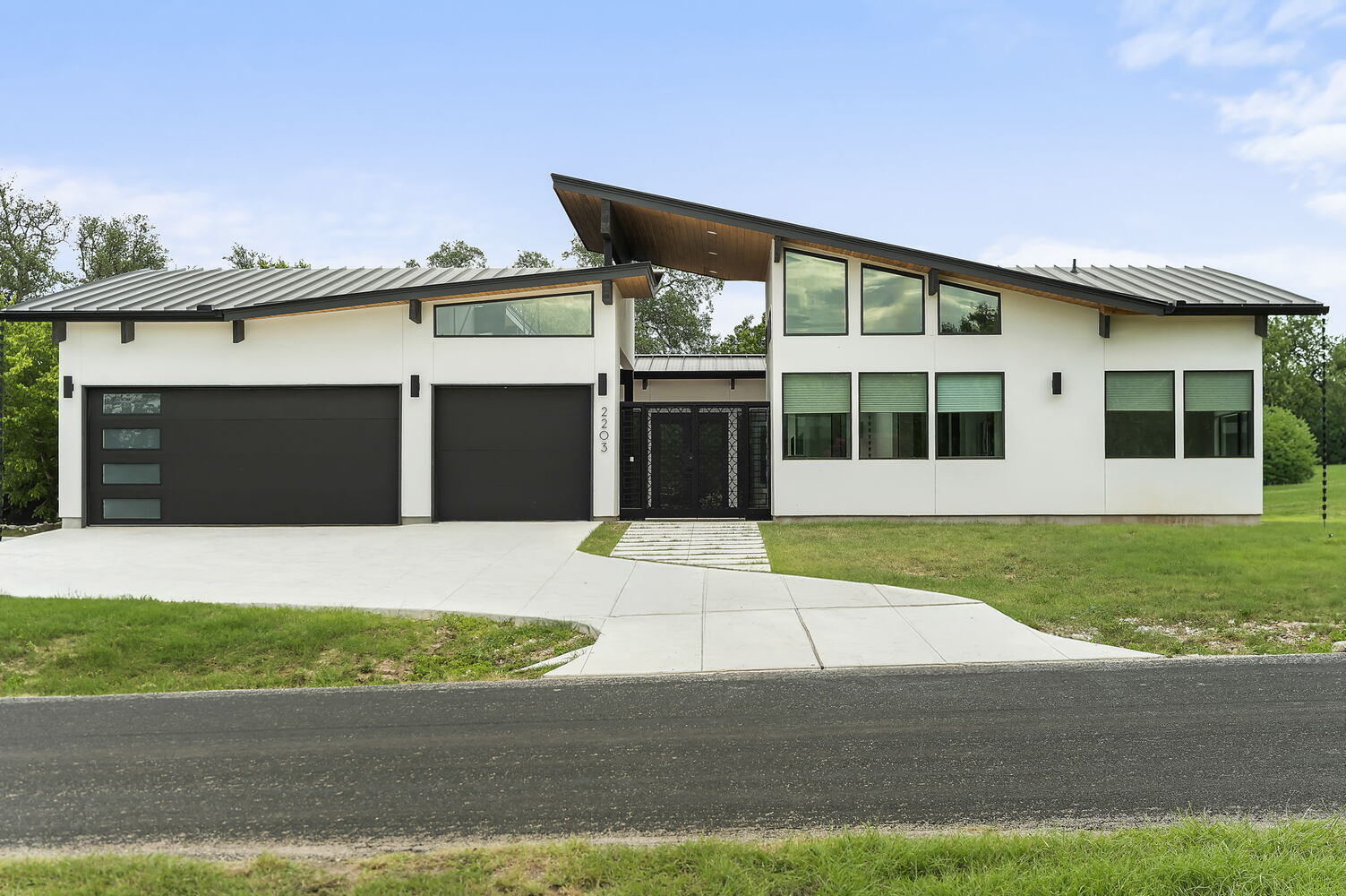 full front view of modern custom home with driveway and entry path by RedOven Builds in San Juan Dr Rio Grande TX