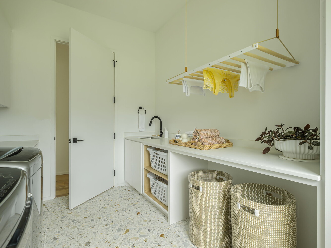laundry room with hanging drying rack and folding counter in custom home by RedOven Builds in Rio Grande TX