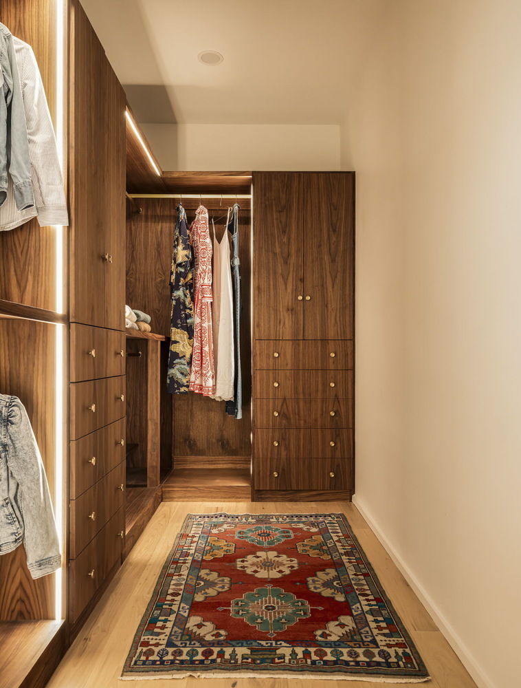 luxury closet with built-in wood storage and hanging space in Rio Grande TX home by RedOven Builds