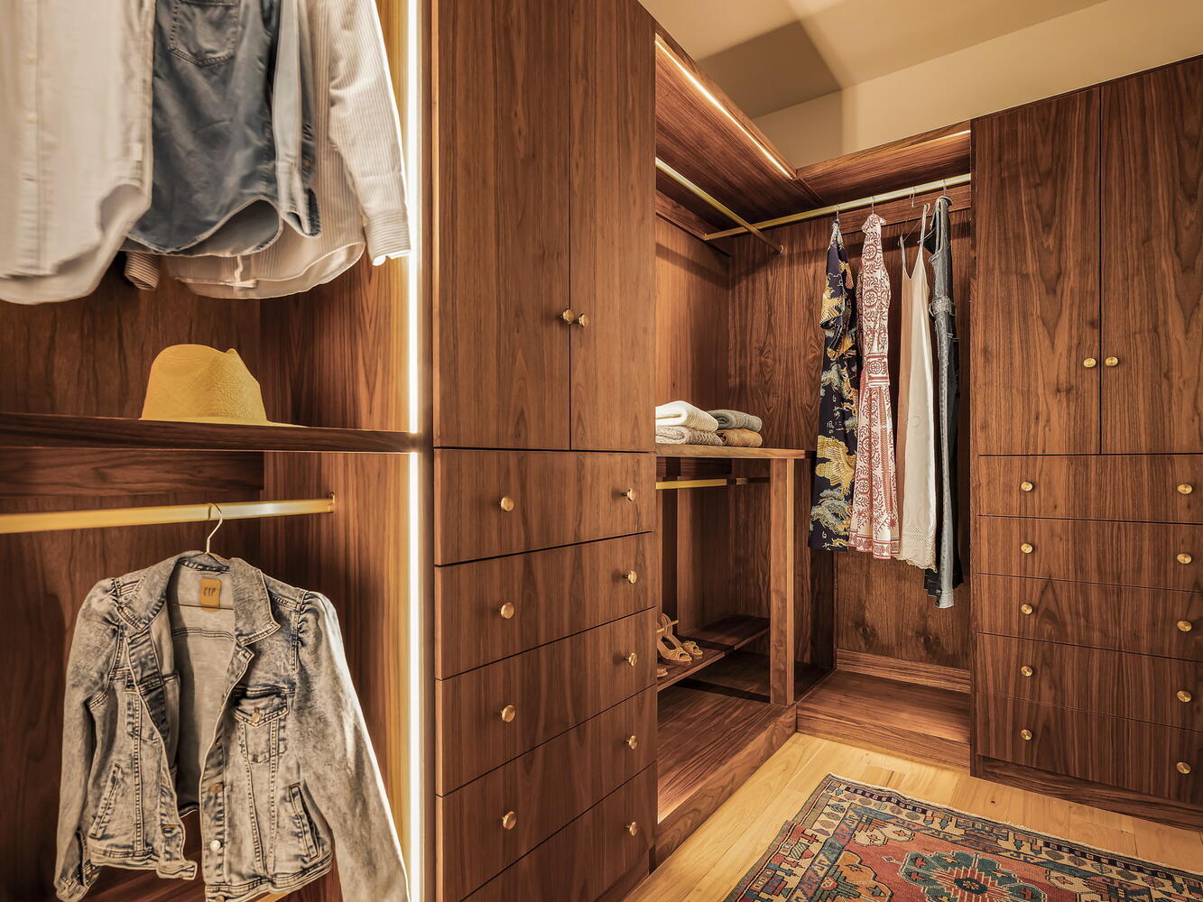 luxury walk-in closet with custom wood cabinets and clothing organization by RedOven Builds in Rio Grande TX
