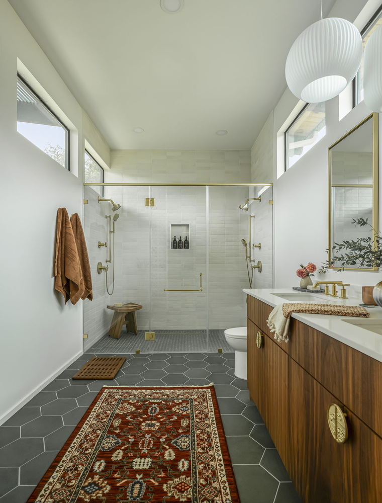 minimalist bathroom with glass shower, wood vanity, and hex tile floor in custom home by RedOven Builds Rio Grande TX