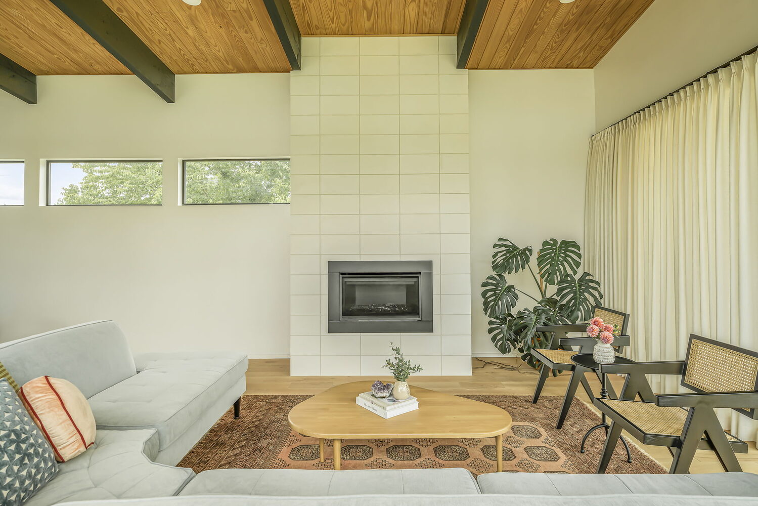 minimalist living room with central fireplace and wood ceiling beams by RedOven Builds San Juan Dr Rio Grande TX