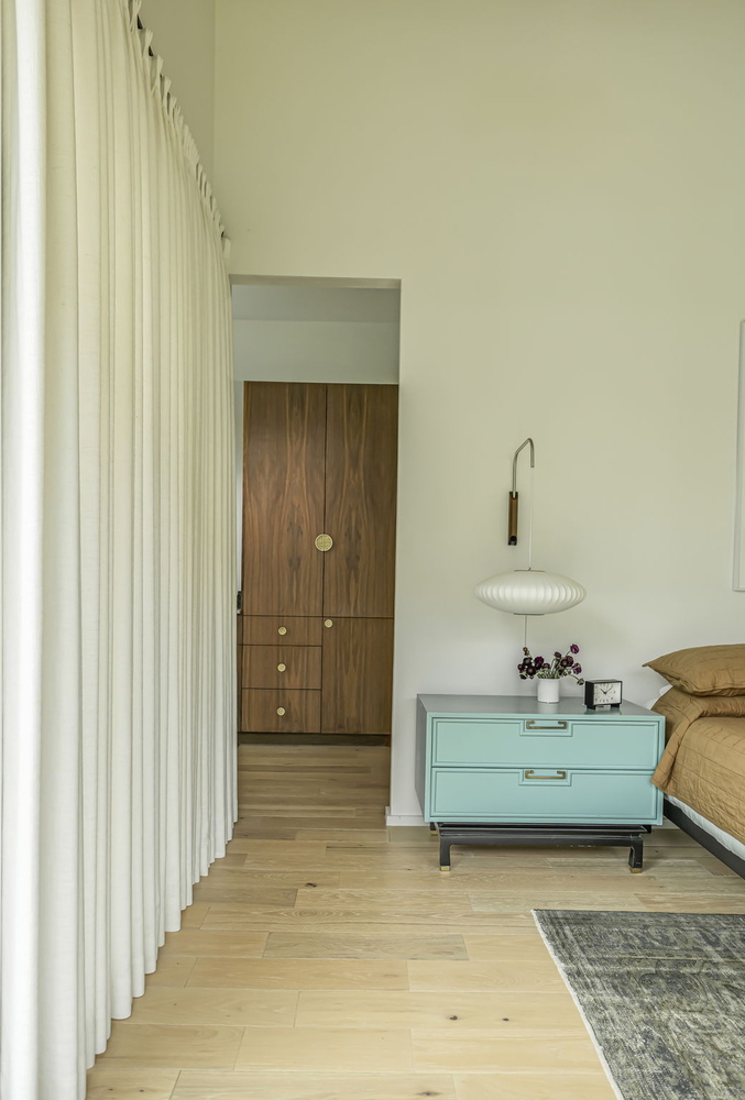 modern bedroom in RedOven Builds custom home featuring soft neutral tones and built-in wood cabinetry in Rio Grande TX