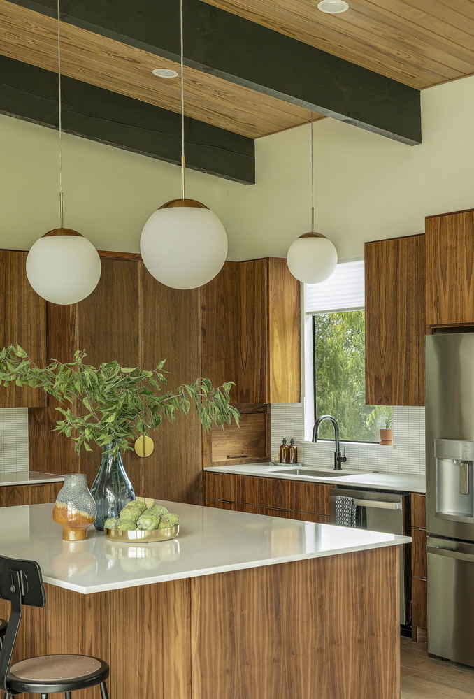 modern kitchen island with white countertop and wood cabinets in RedOven Builds home San Juan Dr Rio Grande TX