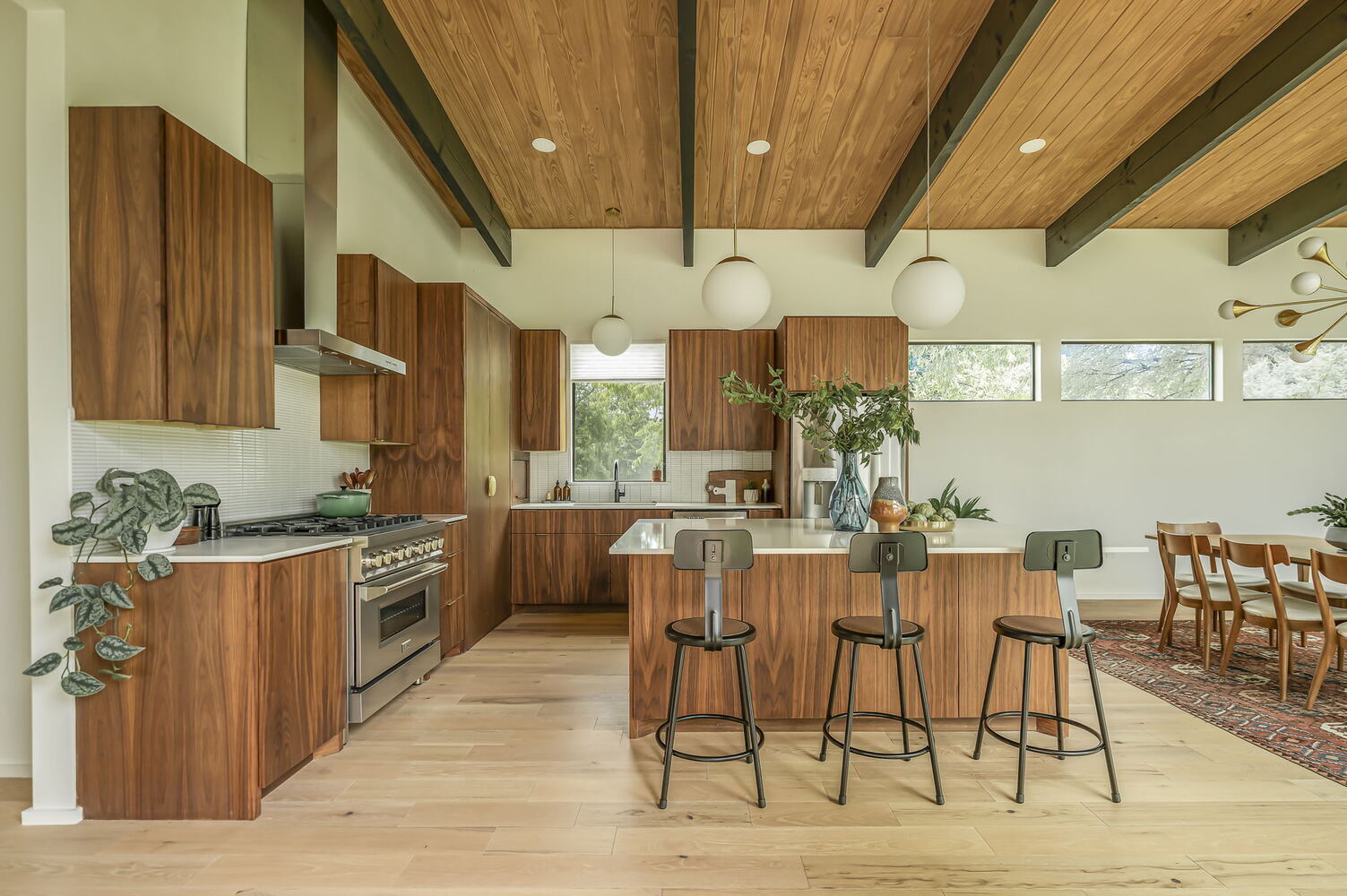 modern kitchen with wood cabinets and island seating in RedOven Builds custom home San Juan Dr Rio Grande TX
