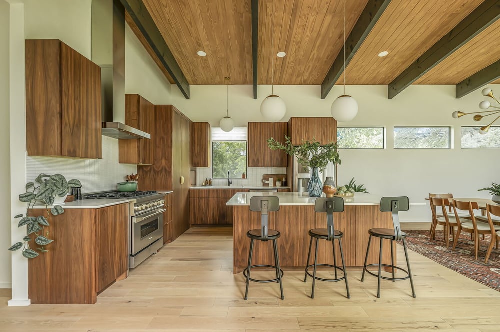 modern kitchen with wood cabinets and island seating in RedOven Builds custom home San Juan Dr Rio Grande TX