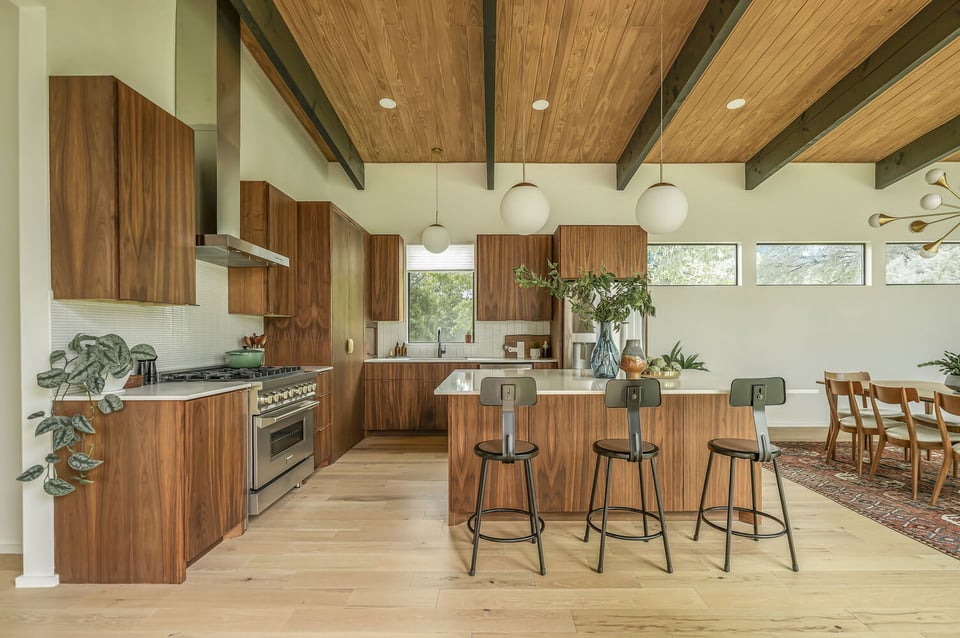 modern kitchen with wood cabinets and island seating in RedOven Builds custom home San Juan Dr Rio Grande TX