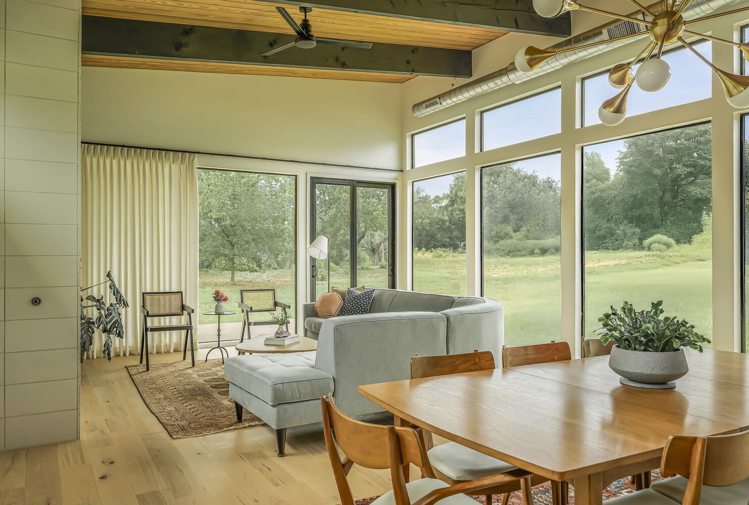 open living and dining area with wood ceiling beams and large windows by RedOven Builds San Juan Dr Rio Grande TX