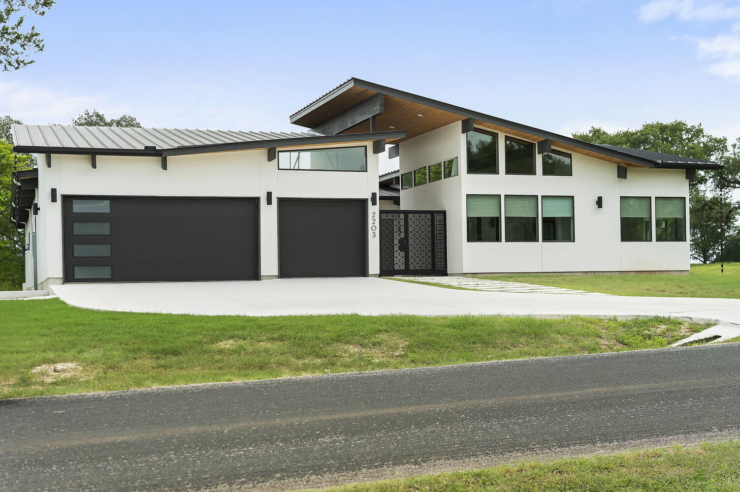 side elevation of modern custom home with large windows by RedOven Builds in San Juan Dr Rio Grande TX