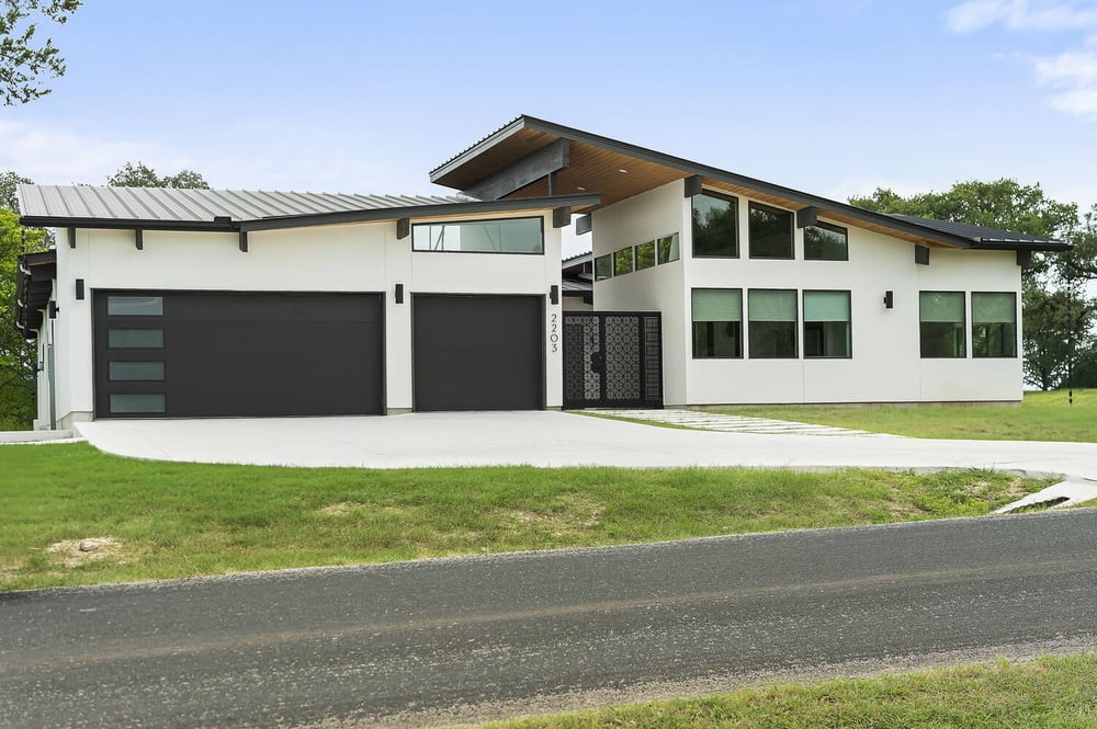 side elevation of modern custom home with large windows by RedOven Builds in San Juan Dr Rio Grande TX