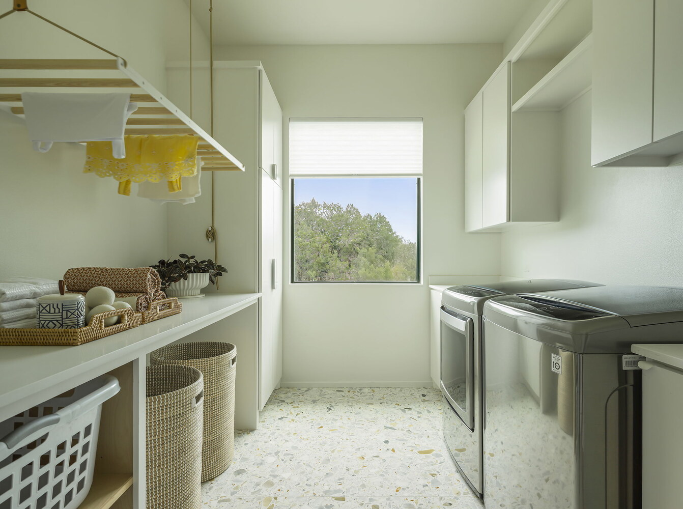 spacious laundry room with folding counter and woven baskets in Rio Grande TX custom home by RedOven Builds